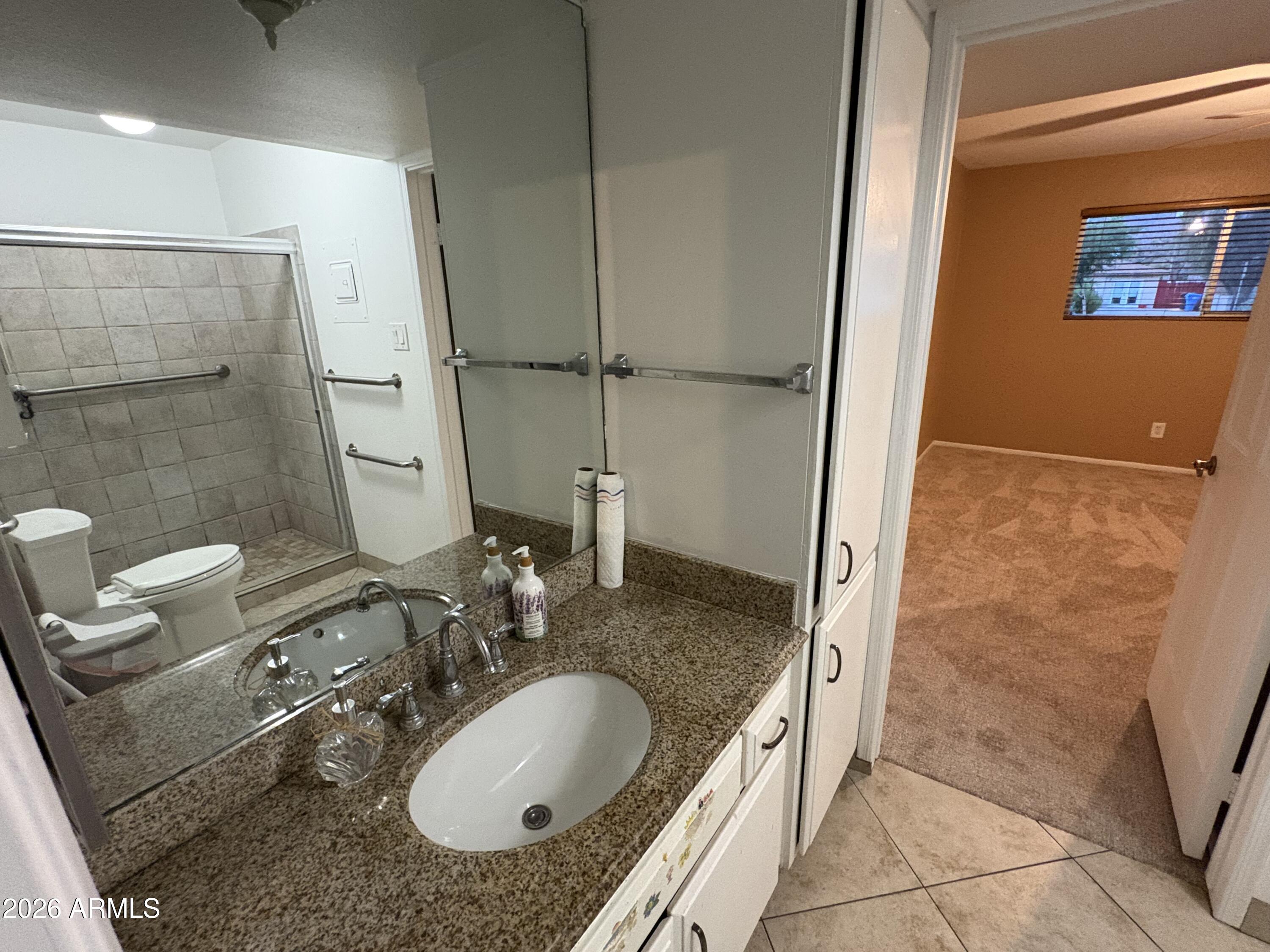 5525 East Thomas Road, Unit A2 Phoenix, AZ 85018 - Photo 6 of 11 a bathroom with a granite countertop sink and a mirror