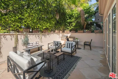 a terrace with outdoor seating and trees