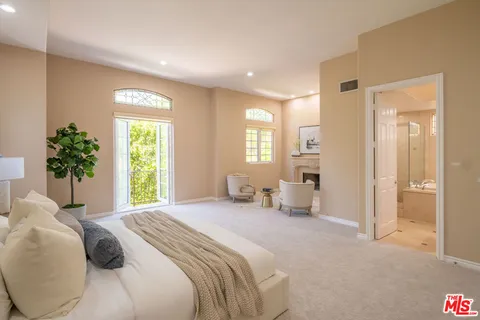 a bedroom with a bed and a large window