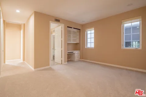 a view of an empty room with a window and bathroom