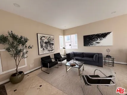 a living room with furniture a couch and a potted plant