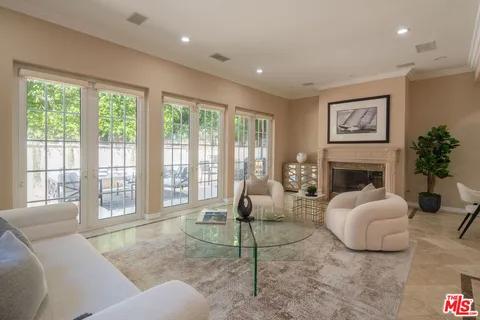 a living room with furniture large window and fireplace