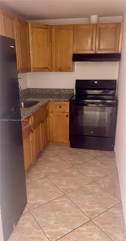 a kitchen with granite countertop a stove and cabinets
