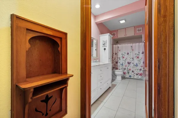 a bathroom with a granite countertop sink a toilet a mirror a vanity and shower