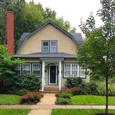 a front view of a house with a yard and potted plants