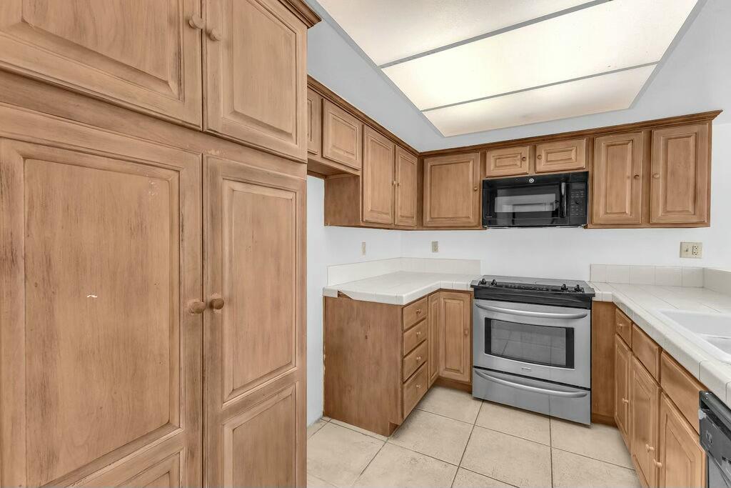 69527 Huerta Court Rancho Mirage, CA 92270 - Photo 6 of 22 a kitchen with stainless steel appliances granite countertop a sink and a stove top oven