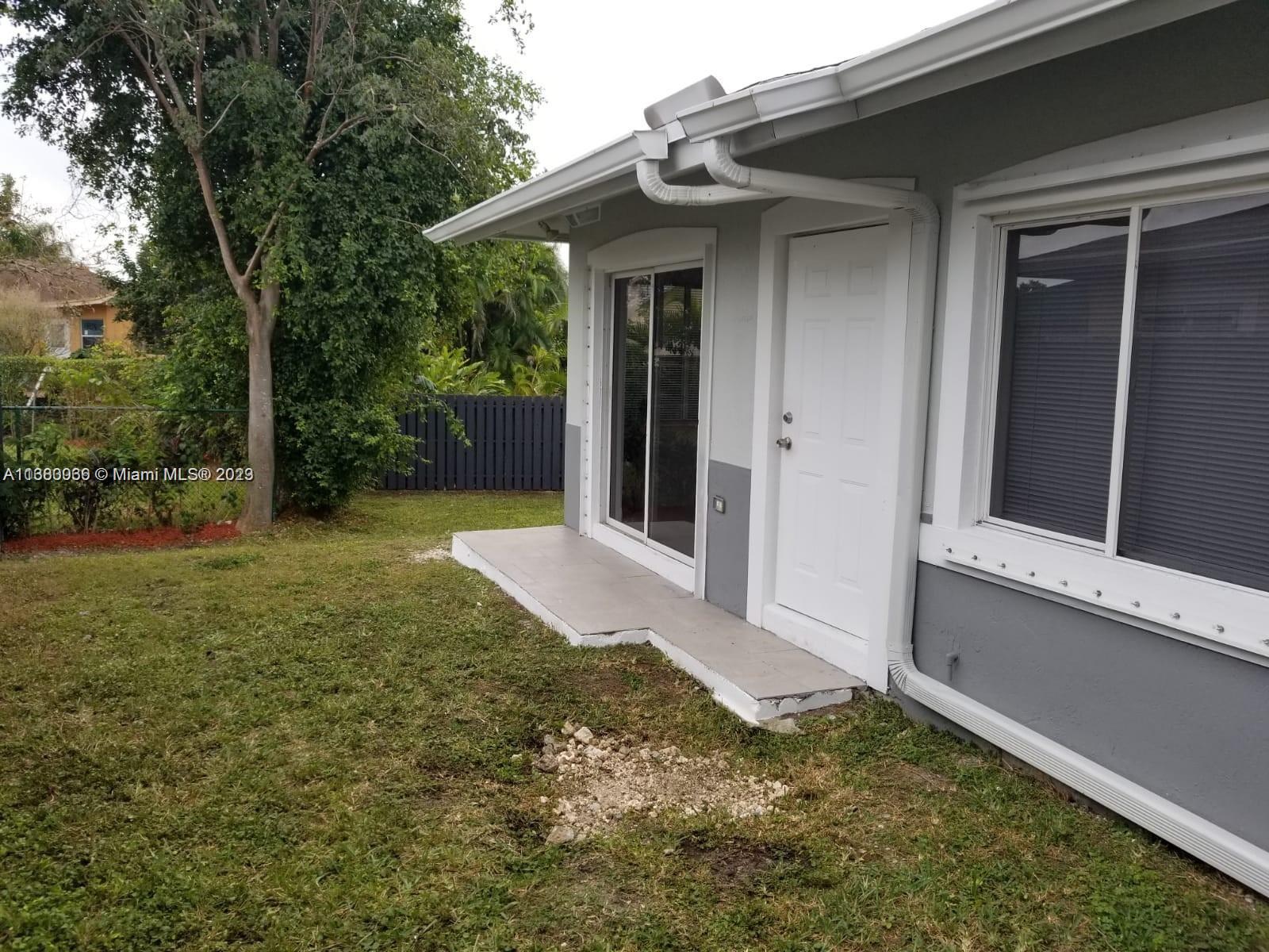 13622 Southwest 285th Terrace Homestead, FL 33033 - Photo 8 of 28 a view of a house with a small yard and floor to ceiling window