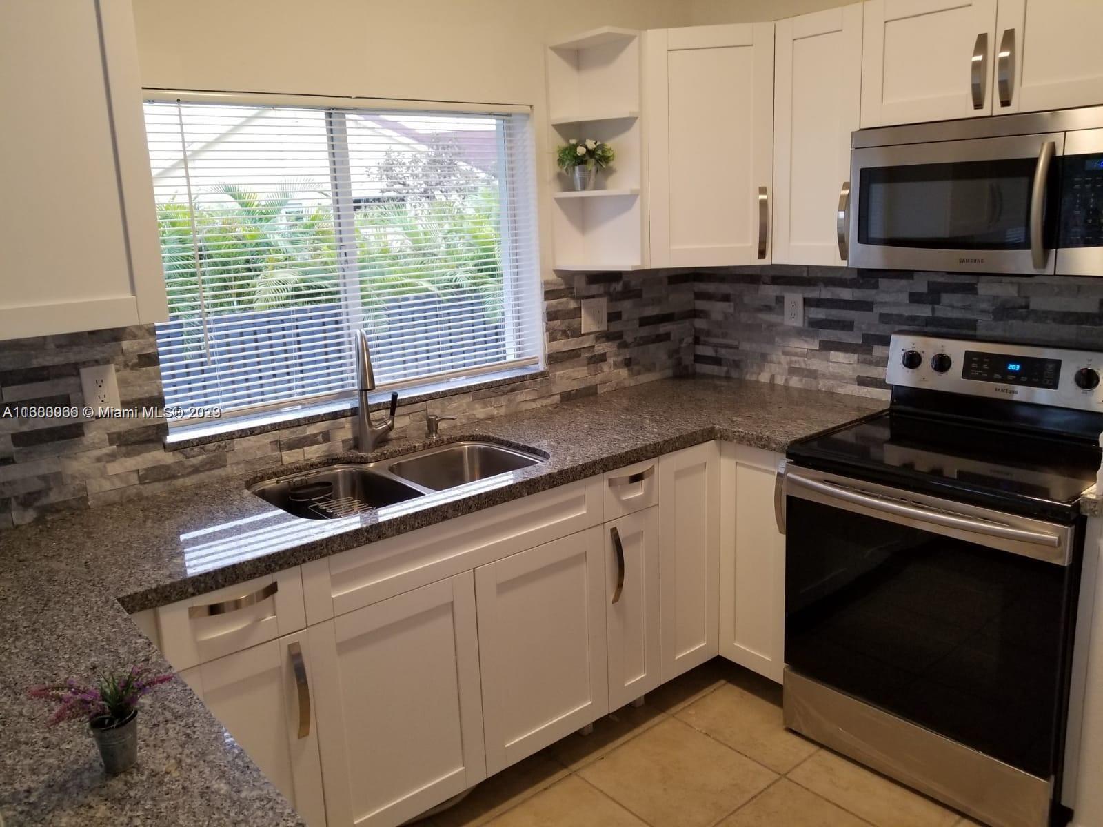 13622 Southwest 285th Terrace Homestead, FL 33033 - Photo 10 of 28 a kitchen with stainless steel appliances granite countertop a sink stove and microwave