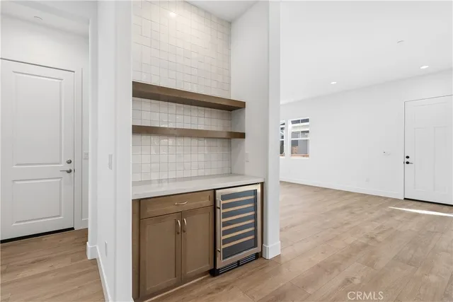 a view of an empty room with wooden floor and closet