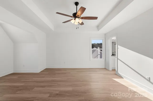 a view of a livingroom with wooden floor and a ceiling fan