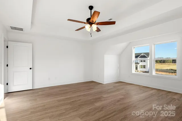 a view of empty room with wooden floor