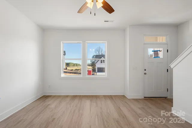 an empty room with a window and wooden floor