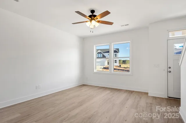 an empty room with window and ceiling fan
