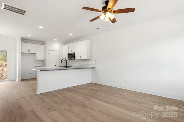 a view of kitchen with granite countertop cabinets and refrigerator