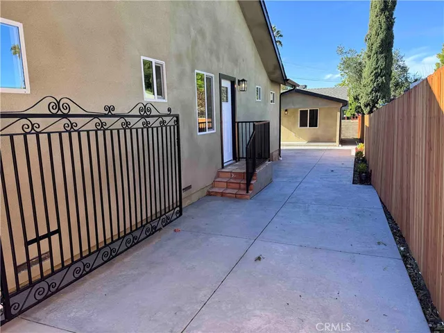 a view of a porch with wooden floor and iron fence