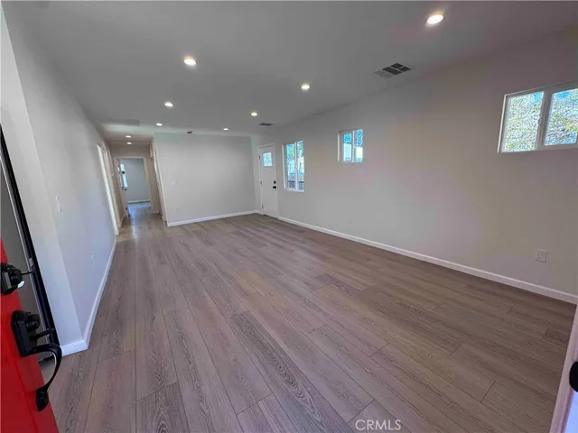 an empty room with wooden floor and window