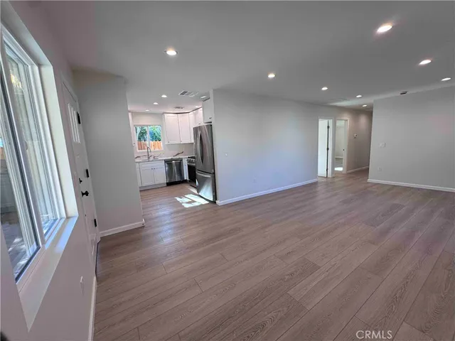 an empty room with wooden floor and a window