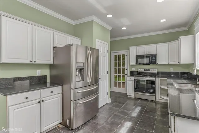 a kitchen with stainless steel appliances granite countertop a refrigerator and a stove top oven