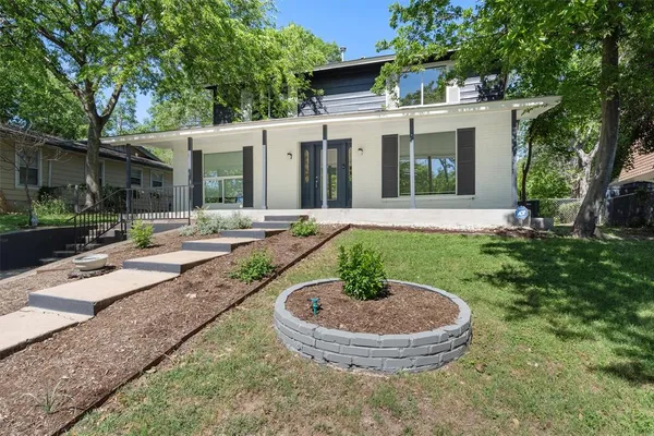 a view of a house with backyard and sitting area