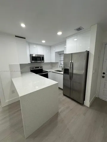 a kitchen with stainless steel appliances a refrigerator and a stove top oven
