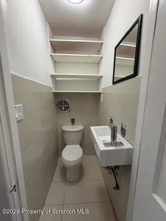 a bathroom with a toilet a sink and mirror
