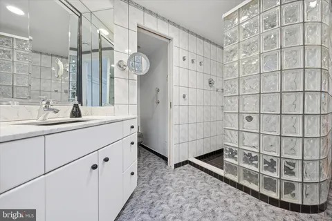 a bathroom with a double vanity sink a mirror and shower