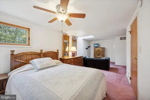 a bedroom with a bed and dresser with mirror