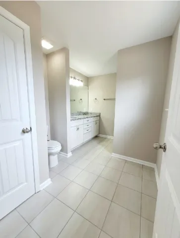 a bathroom with a granite countertop sink a toilet and a mirror