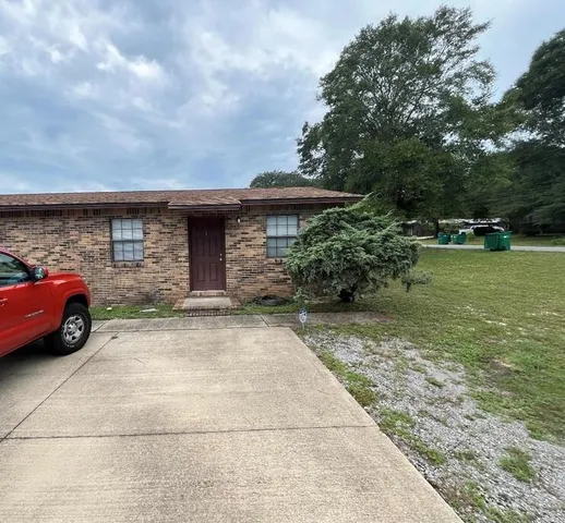 a view of backyard with large trees and plants