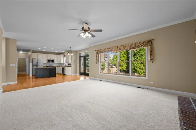 a view of empty room with a kitchen and a window