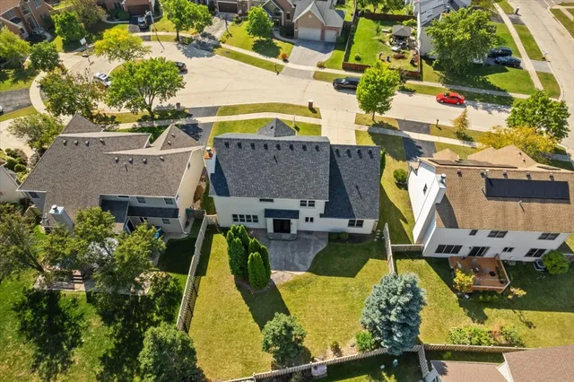 an aerial view of a house with swimming pool and large trees