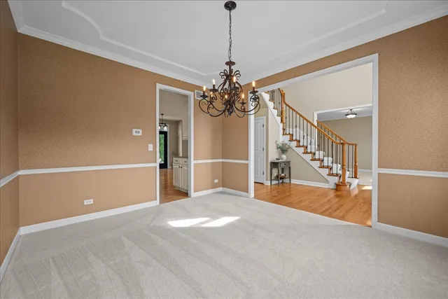 a view of a livingroom with a chandelier fan and windows