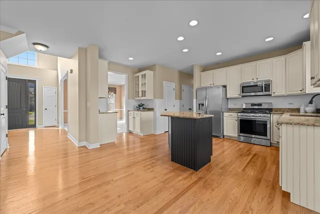 a large kitchen with stainless steel appliances kitchen island granite countertop a stove top oven a sink and a refrigerator