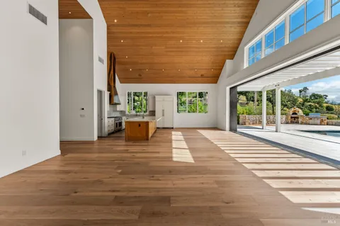 a living room with furniture a flat screen tv and a floor to ceiling window