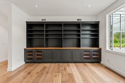 an empty room with wooden floor and window