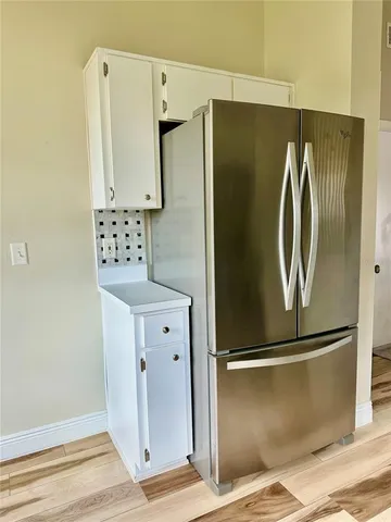 a walk in closet with wooden floor