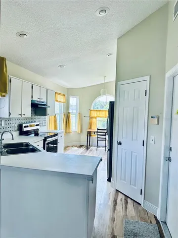 a kitchen with granite countertop a refrigerator stove top oven and sink