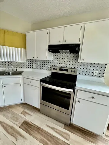 a kitchen with granite countertop a stove a sink and a microwave