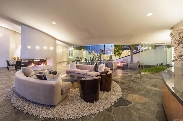 a living room with furniture potted plant and a large window