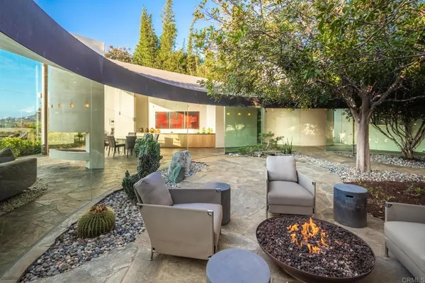 a view of a patio with couches table and chairs under an umbrella