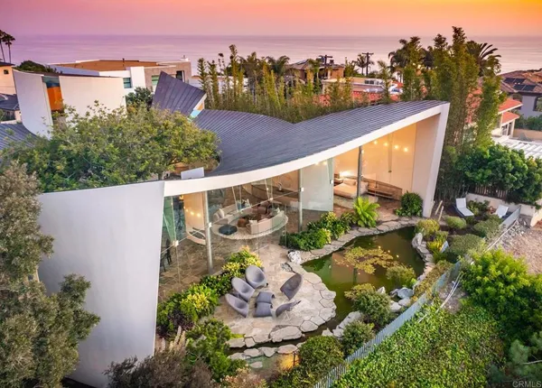 an aerial view of a house with a garden and lake view