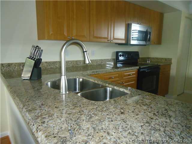 1821 Southwest Palm City Road, Unit B102 Stuart, FL 34994 - Photo 8 of 18 Kitchen. Kitchen with granite countertop, stainless sink; refrigerator and microwave