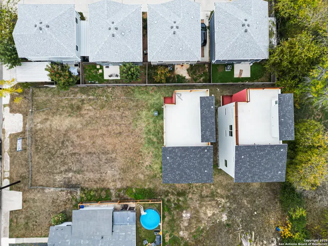 an aerial view of a house with a yard and large trees