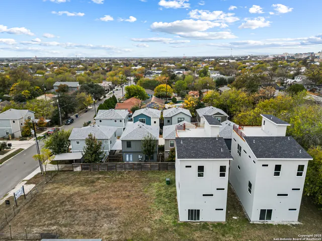 an aerial view of residential houses with outdoor space and ocean view