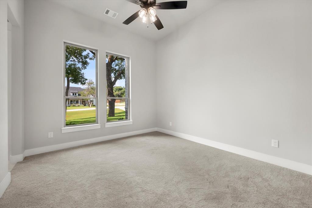 7631 Woodstream Road Midlothian, TX 76065 - Photo 33 of 40 Vaulted ceiling with a ceiling fan, light gray wall paint, two large windows, white trim, and gray carpet flooring