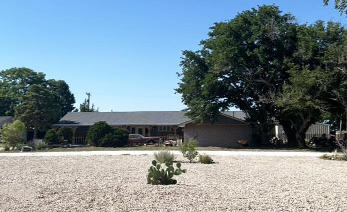 1907 Highway 70 Muleshoe, TX 79347 - Photo 2 of 34 a front view of house with yard and trees in the background