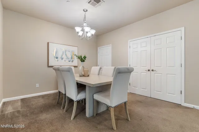 a view of a dining room with furniture a chandelier and a window