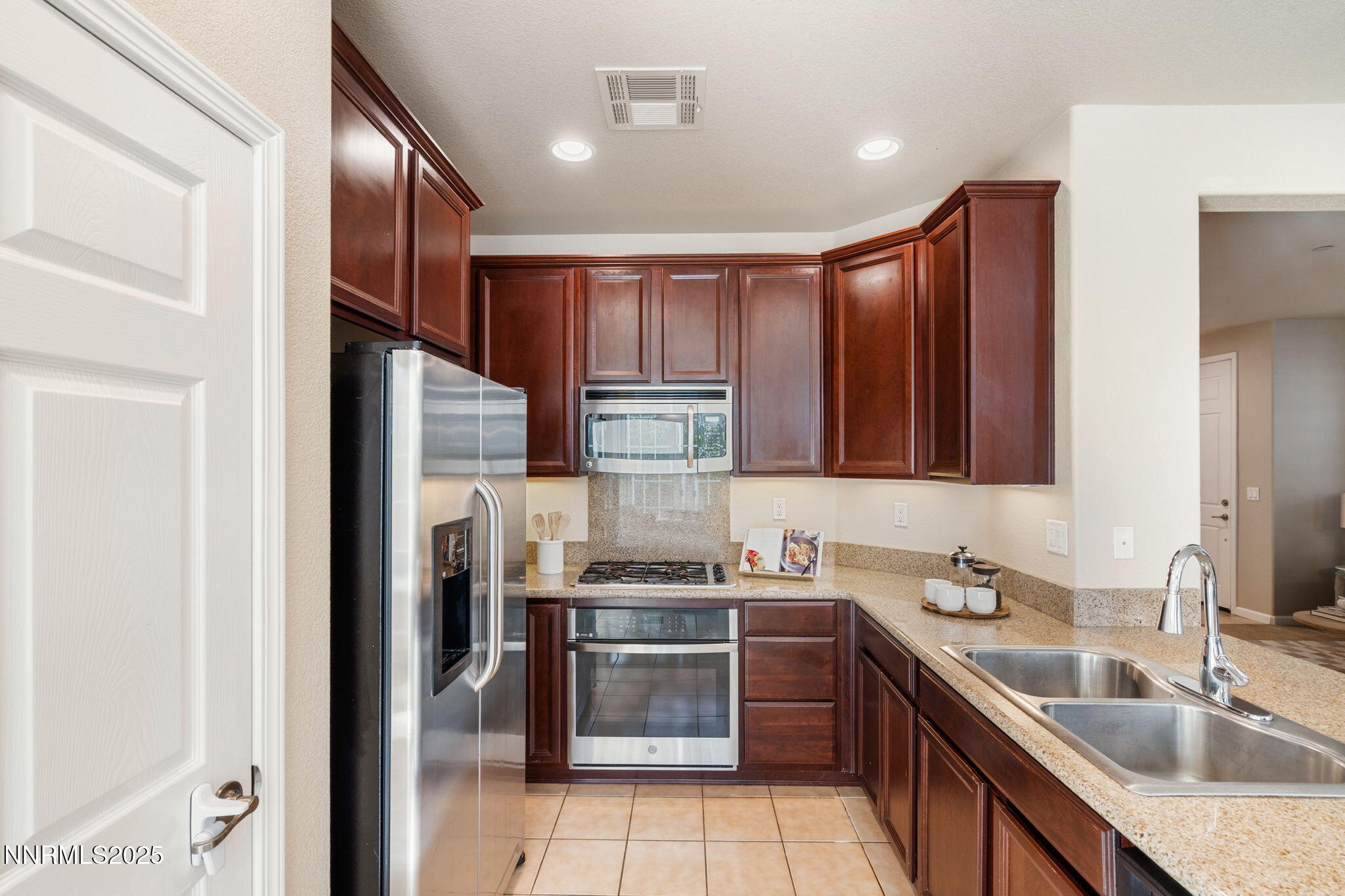 1865 Wind Ranch Road, Unit A Reno, NV 89521 - Photo 10 of 30 a kitchen with kitchen island granite countertop a sink stainless steel appliances and cabinets
