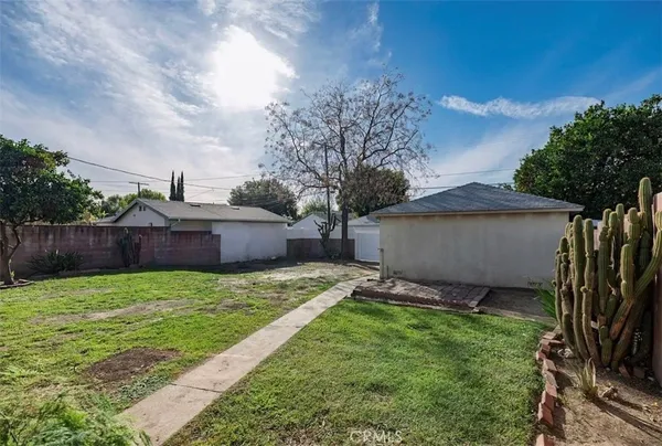 a view of a backyard with potted plants and a large tree