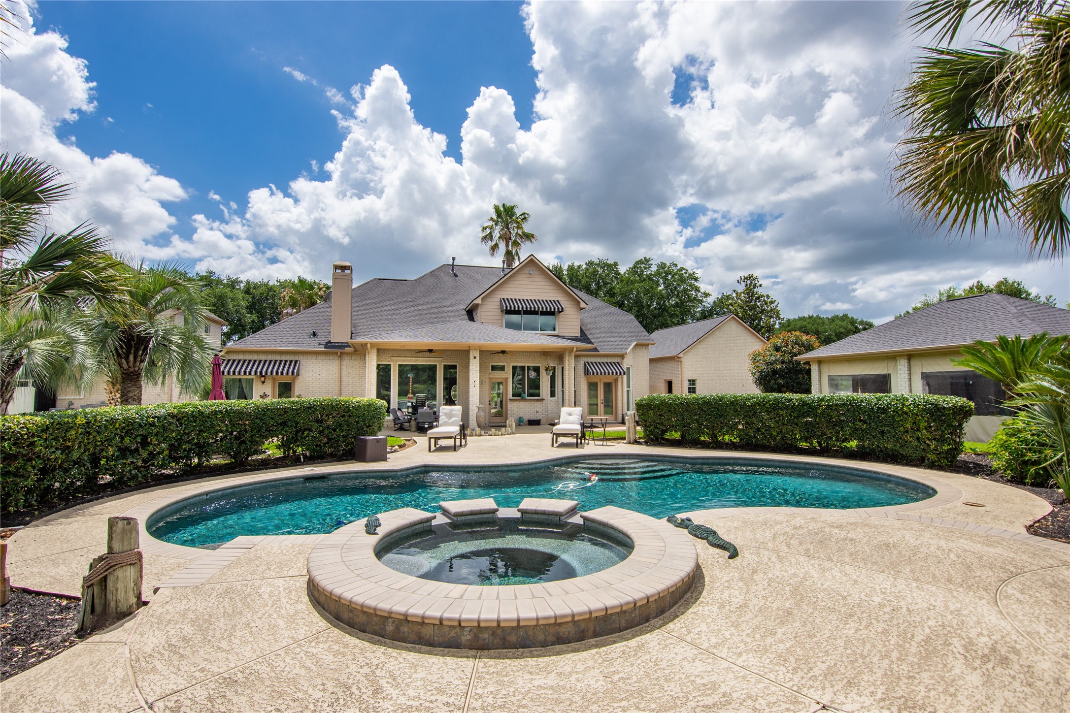 13914 Skinner Road Cypress, TX 77429 - Photo 44 of 50 Backyard pool area centered around a raised spa, with wide patio space, tropical landscaping, and easy access to the surrounding living areas.